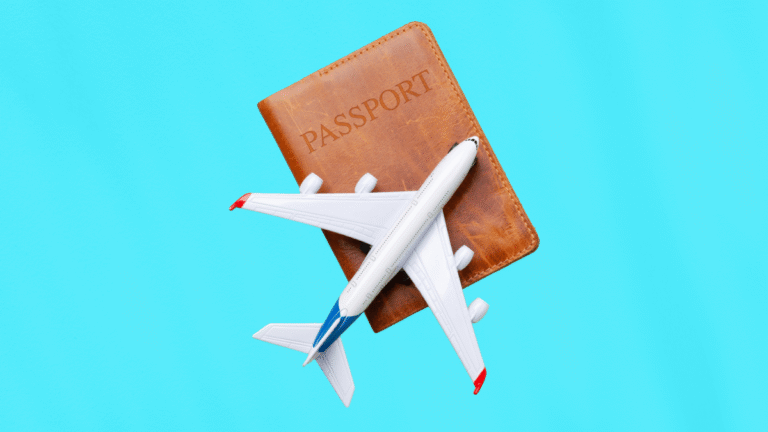 Passeport et avion miniature sur fond bleu, symbolisant les préparatifs clés d’un voyage d’affaires à l’étranger.