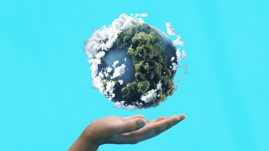 Main tendue sous une planète recouverte de forêts et de nuages, illustrant la responsabilité sociétale des entreprises (RSE) et l’engagement environnemental.