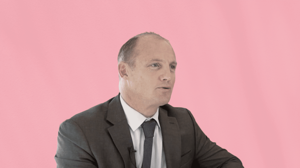 Guillaume Bredon, en costume, lors d’un témoignage client en tant qu’associé chez BRL Avocats, sur fond rose uni.