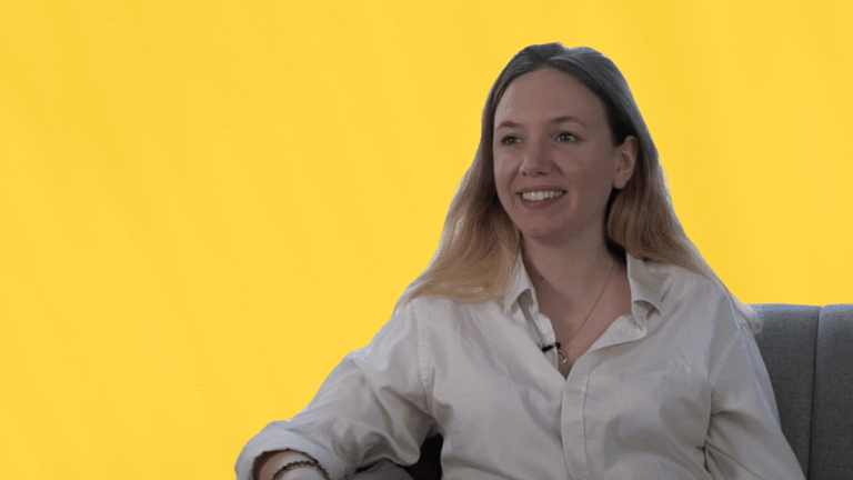 Lucie, office manager chez Blade, partage son témoignage client, assise sur un fauteuil, souriante, en chemise blanche, sur fond jaune.