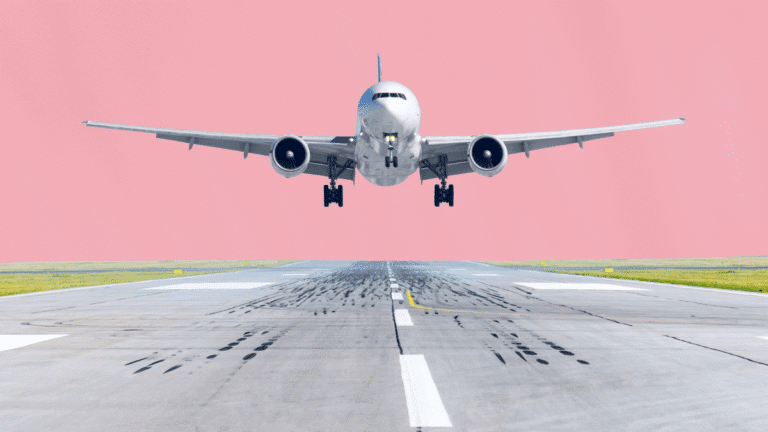 Image conceptuelle illustrant la norme NDC : un avion de ligne blanc en phase d'atterrissage immédiat, centré au-dessus d'une piste d'aéroport marquée de traces de pneus. L'arrière-plan est un aplat de couleur rose uni, symbolisant la modernisation et la simplification des flux de distribution directe entre les compagnies aériennes et les agences de voyages.