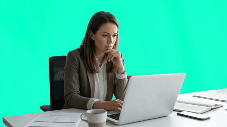 Une professionnelle pensive travaille sur son ordinateur portable dans un bureau, illustrant la rigueur nécessaire pour la gestion des voyages d'affaires.