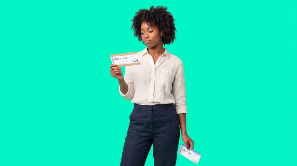 Une salariée compare un billet de TGV Paris-Lyon et une carte d'embarquement pour choisir entre l'avion et le train en déplacement professionnel.