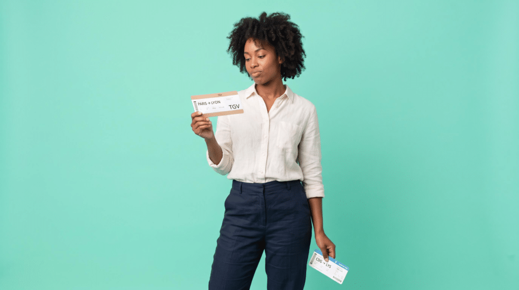 Une salariée compare un billet de TGV Paris-Lyon et une carte d'embarquement pour choisir entre l'avion et le train en déplacement professionnel.