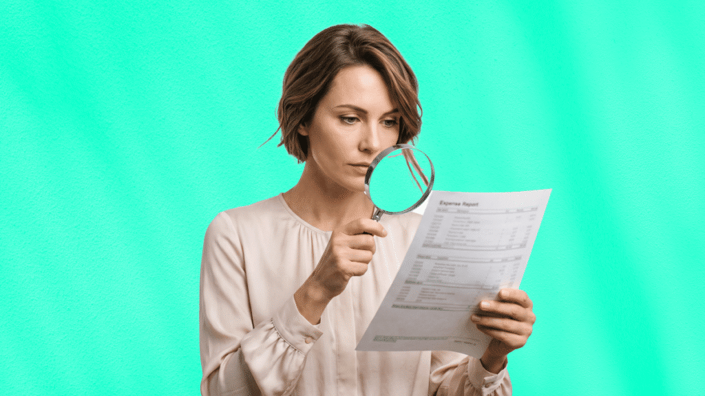Femme examinant un rapport de dépenses avec une loupe pour détecter une fraude aux notes de frais.